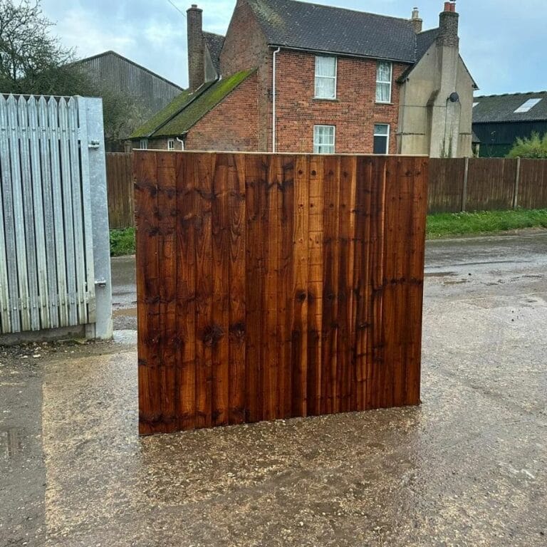 Dark-stained closeboard wooden fence panel displayed upright on a paved surface.